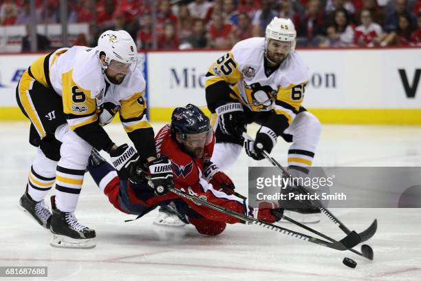 Brian Dumoulin and Ron Hainsey of the Pittsburgh Penguins go after the puck against Justin Williams of the Washington Capitals in the third period in...