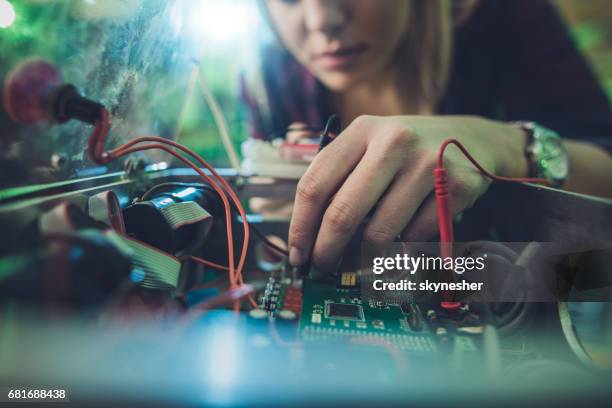 close up van een vrouw die herstellen van elektrische onderdelen van een computer. - elektronica stockfoto's en -beelden