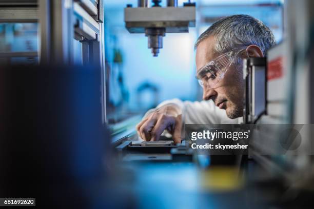 trabajador de control de calidad análisis de experimento científico en una máquina de fabricación. - ingeniero fotografías e imágenes de stock