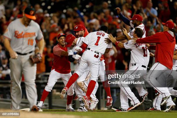 Matt Wieters of the Washington Nationals is swarmed by his teammates after hitting a single two run RBI walk-off during the ninth inning to defeat...