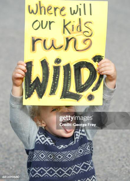 Gus Waggoner, holds a protest sign at a protest against U.S. Secretary of the Interior Ryan Zinke : as he arrives at the Kanab Airport on May 10,...