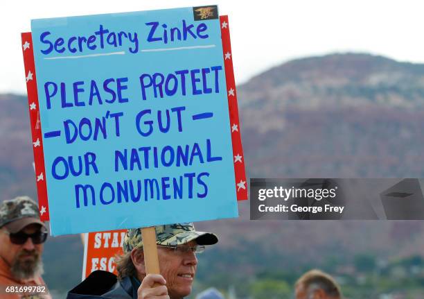 Man holds a sign as he waits at the Kanab Airport to protest U.S. Secretary of the Interior Ryan Zinke on May 10, 2017 in Kanab, Utah. Zinke has been...