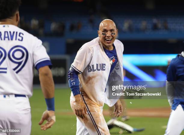 Ryan Goins of the Toronto Blue Jays reacts after being doused by Devon Travis after his game-winning RBI single in the ninth inning during MLB game...