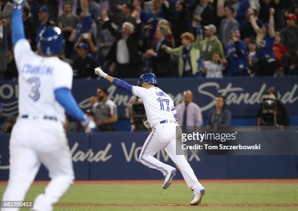 Ryan Goins of the Toronto Blue Jays is celebrates as he hits a game-winning RBI single as Ezequiel Carrera jogs home to score the winning run in the...