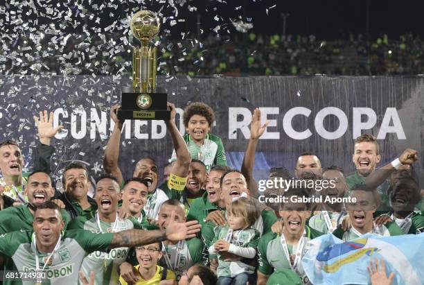 Alexis Henriquez of Nacional lifts the trophy to celebrate with teammates after winning a match between Atletico Nacional and Chapecoense as part of...