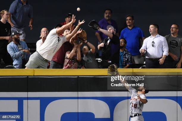 Tyler Collins of the Detroit Tigers watches as fans attempt to catch a home run ball off the bat of Brandon Drury of the Arizona Diamondbacks during...