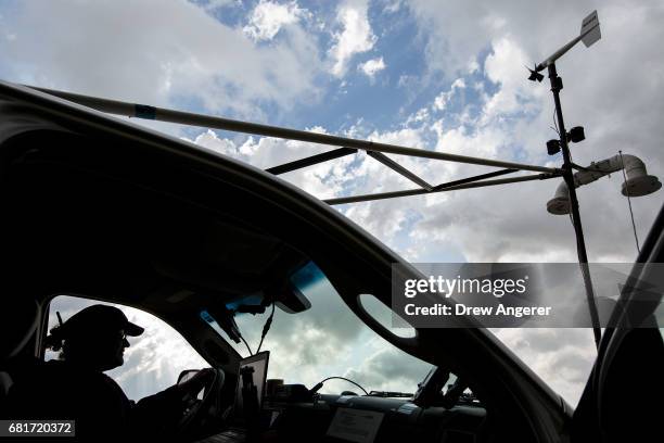 Support scientist Rachel Humphrey relaxes in the tornado scout vehicle at the end of a day of chasing supercell thunderstorms in hopes of...