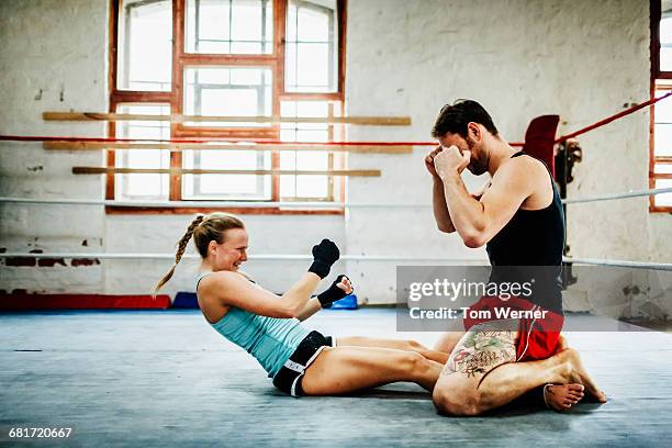 Female boxer doing situps in boxing ring