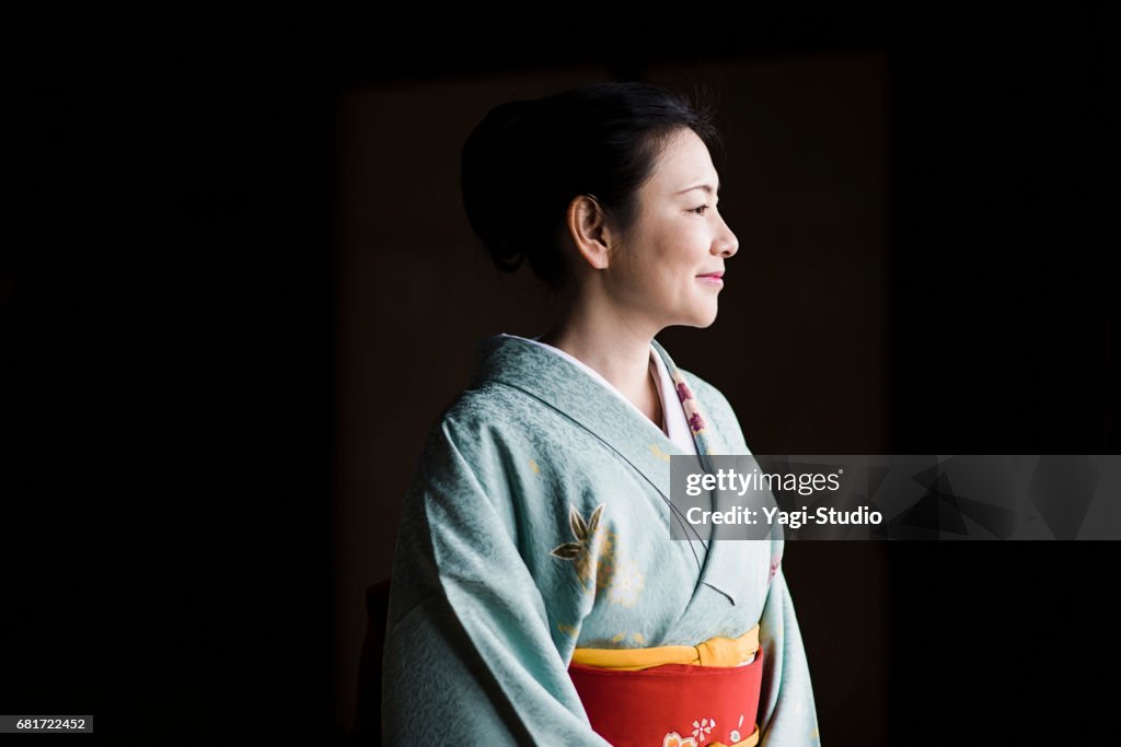 Reife Frau in einem Kimono in einem Tempel