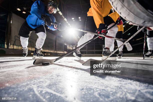 below view of ice hockey players in action during the match. - indoor ice rink stock pictures, royalty-free photos & images