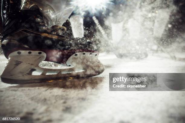 close up of ice hockey player's skate on ice. - hockey puck stock pictures, royalty-free photos & images