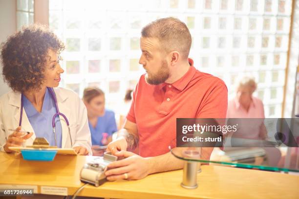 paying for his treatment - busy hospital lobby stock pictures, royalty-free photos & images