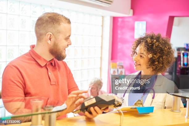 settling his medical bill - busy hospital lobby stock pictures, royalty-free photos & images