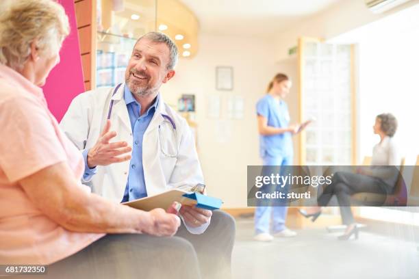 smiling doctor delivers the good news - waiting room stock pictures, royalty-free photos & images