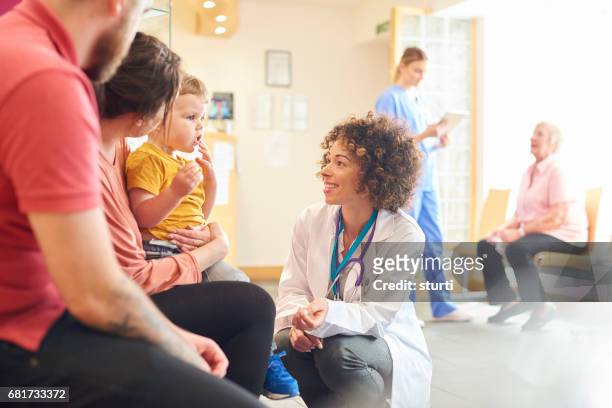 kleinkind im gespräch mit ärztin - kind im krankenhaus stock-fotos und bilder