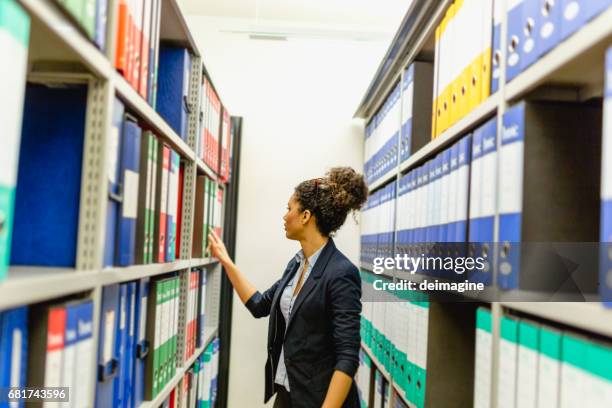 secretary woman in basement archive - file cabinet stock pictures, royalty-free photos & images