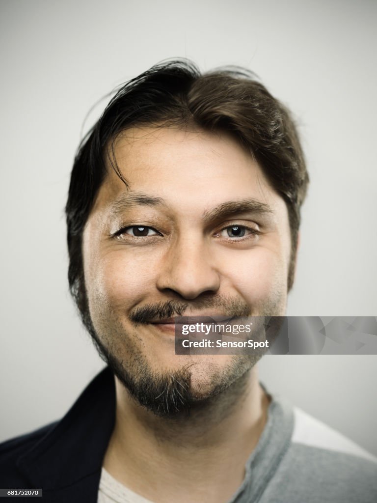 Mman excité souriant sur fond gris