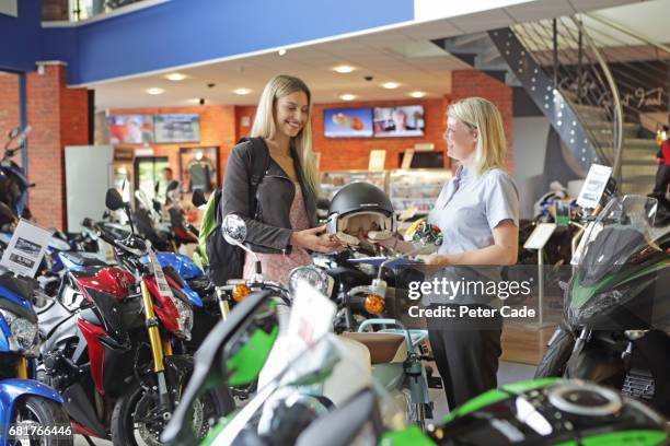 young woman buying helmet in motorbike showroom - buying a bike bildbanksfoton och bilder