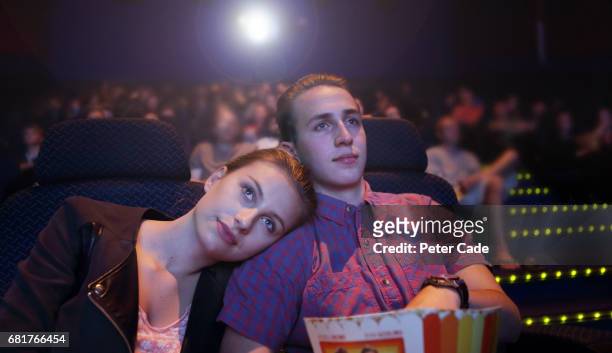 young couple in cinema - filmindustrie stock-fotos und bilder