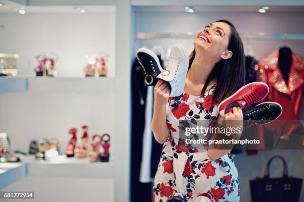 girl is choosing shoes in a boutique and make fun - desire stock pictures, royalty-free photos & images