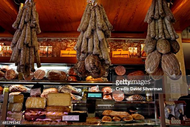 Salamis hang over the meat counter at the renowned Tamburini salsamenteria on March 29, 2017 in Bologna, Italy. Located in the Quadrilatero market,...