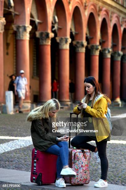 Tourists used their mobile phones in front of one of the city's famous covered arcades in Piazza Santo Stefano on March 31, 2017 in central Bologna,...