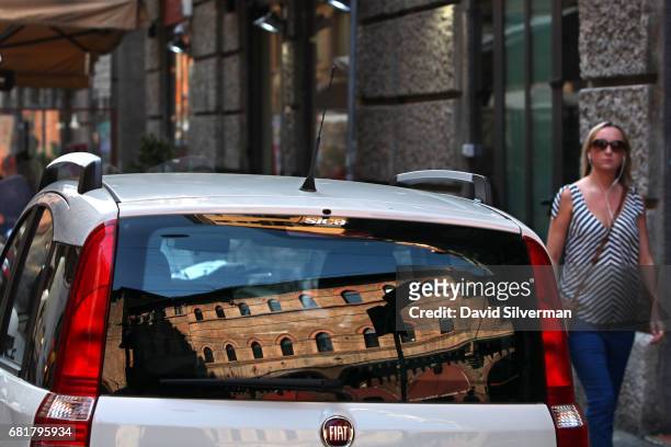 The Palazzo della Mercanzia is seen reflected in the rear window of a parked car on March 31, 2017 in Bologna, Italy. The 14th century building is...