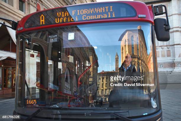 View of the Piazza Maggiore is reflected in a public bus window on March 30, 2017 in Bologna, Italy. Bologna has three nicknames: Situated in the...