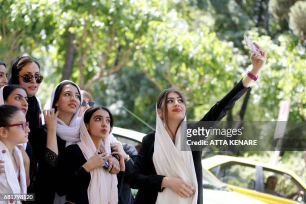 Supporters of Iranian conservative presidential candidate, Tehran mayor Mohammad Bagher Ghalibaf, pose for a selfie during a campaign rally in the...