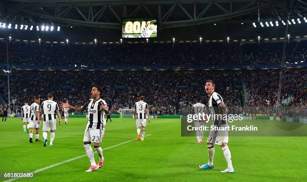 Mario Mandzukic of Juventus celebrates after scoring his goal with Dani Alves during the UEFA Champions League Semi Final second leg match between...