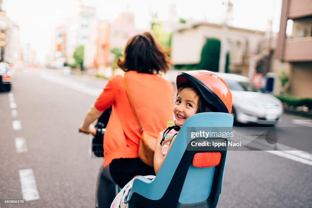 Cycling with a toddler girl in urban city, Tokyo