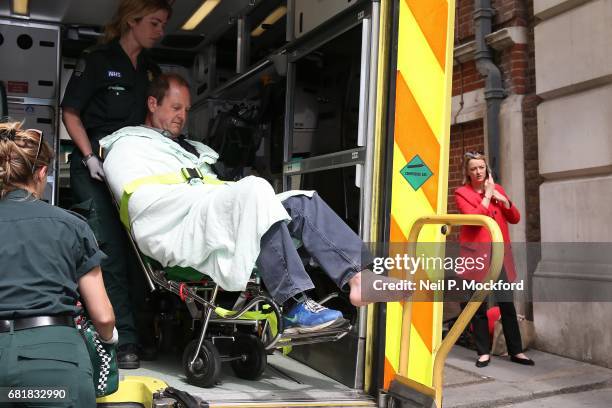 Cameraman Giles Wooltorton is helped by Ambulance staff after reportedly being hit by Labour Leader Jeremy Corbyn's vehicle outside Savoy Place, as...