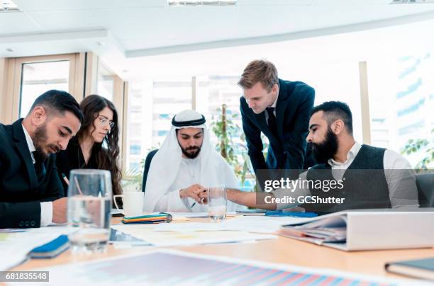 business-meeting im gange, die unter dem vorsitz von arabischen geschäftsmann - emirati at work stock-fotos und bilder