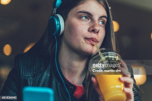 adolescente beber jugo de naranja - mp3 juices fotografías e imágenes de stock