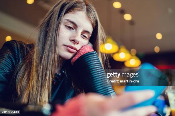 bored girl in cafe texting - teenage romance stock pictures, royalty-free photos & images