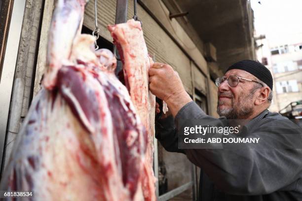 Syrian butcher slaughters a camel in the rebel-held town of Douma, on the eastern outskirts of Damascus on May 11, 2017. Before the Syrian war the...