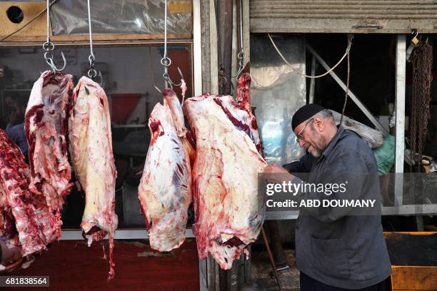 Syrian butcher slaughters a camel in the rebel-held town of Douma, on the eastern outskirts of Damascus on May 11, 2017. Before the Syrian war the...