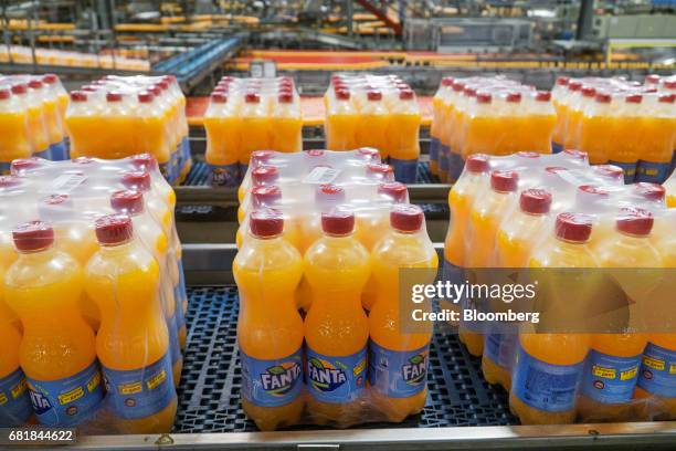 Plastic wrapped bottle packs of Fanta fruit soda move along the automated production line at the Coca-Cola Hellenic Bottling Co. SA plant in Brovary,...