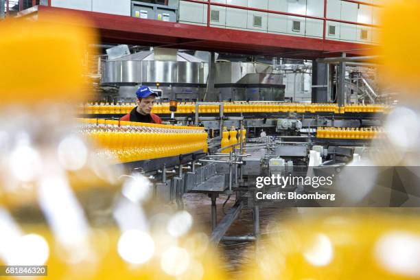Worker monitors the automated Fanta fruit soda bottling line at the Coca-Cola Hellenic Bottling Co. SA plant in Brovary, Ukraine, on Wednesday, May...