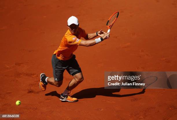 Kei Nishikori of Japan plays a backhand in his match against David Ferrer of Spain during day six of the Mutua Madrid Open tennis at La Caja Magica...