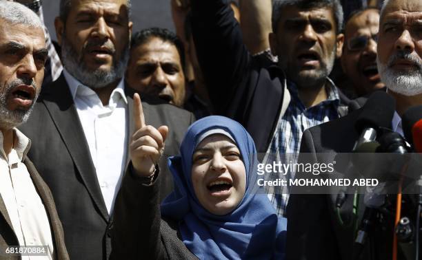 The widow of the Islamist movement Hamas' killed military commander Mazen Faqha speaks alongside the group leader Ismail Haniya at a press conference...