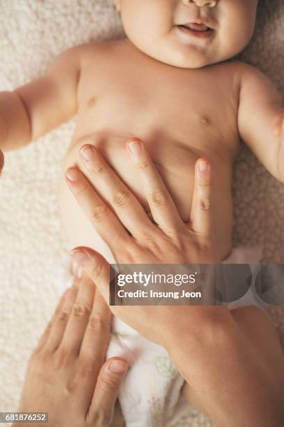 baby girl (6-11 months) receiving hand massage - asian massage girl stock-fotos und bilder