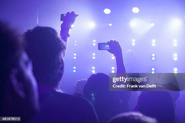 rear view of group in club arms raised filming concert on smartphone - music festival phone stock pictures, royalty-free photos & images