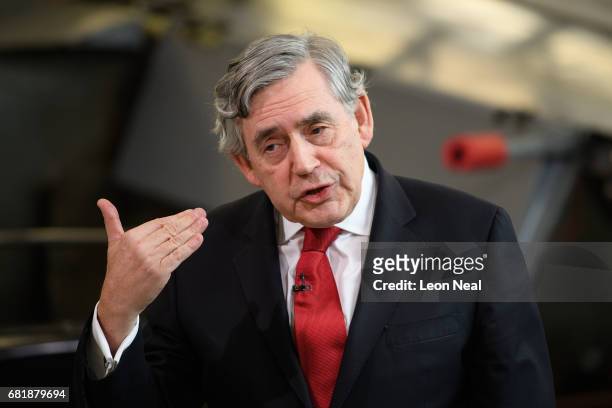 Former British Prime Minister Gordon Brown stands in front of a Jump Jet Harrier fighter plane as he addresses Labour supporters at a rally in the...