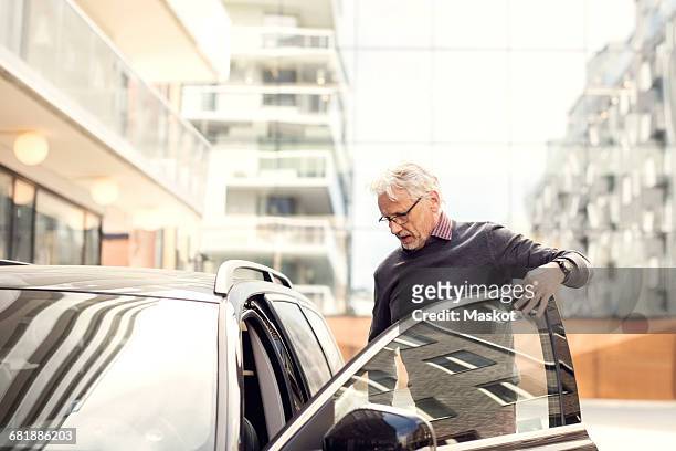 senior man disembarking from car in city - gå i land bildbanksfoton och bilder
