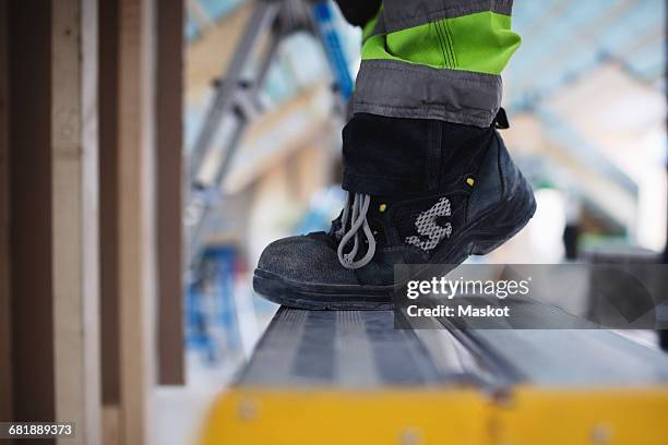 low section of man wearing shoes standing on ladder - work shoe stock pictures, royalty-free photos & images