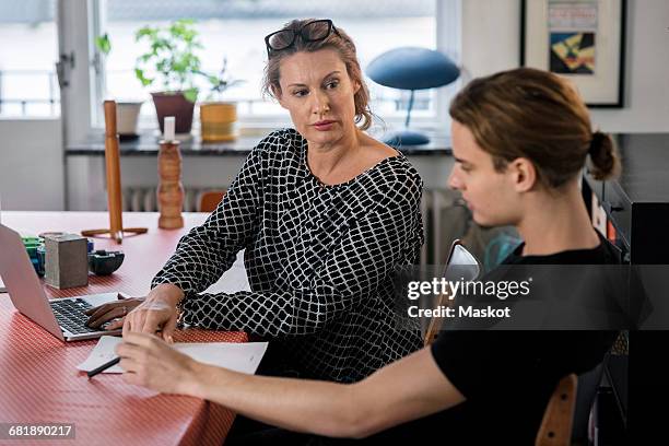mother and son using laptop at dining table - mature woman and son imagens e fotografias de stock
