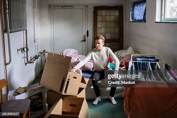 man unpacking cardboard box in new home - bedroom doorway stock pictures, royalty-free photos & images