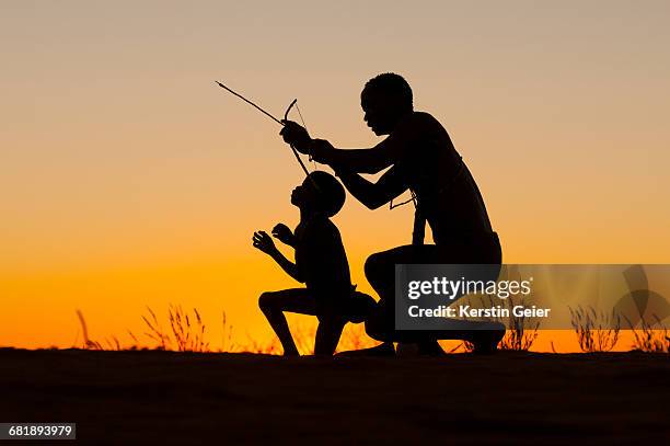 silhouette of san (bushmen) on top of dunes at sunset. stampriet district, namibia. - kalahari desert 個照片及圖片檔