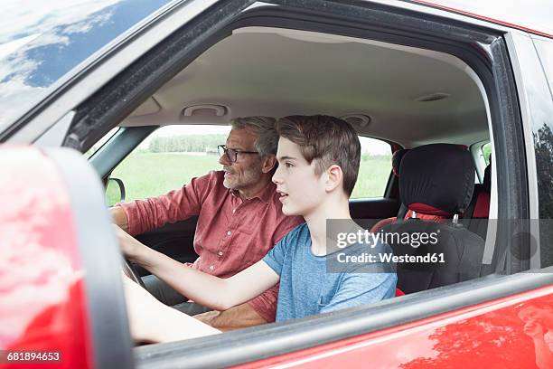 father teaching son driving a car - learning to drive ストックフォトと画像